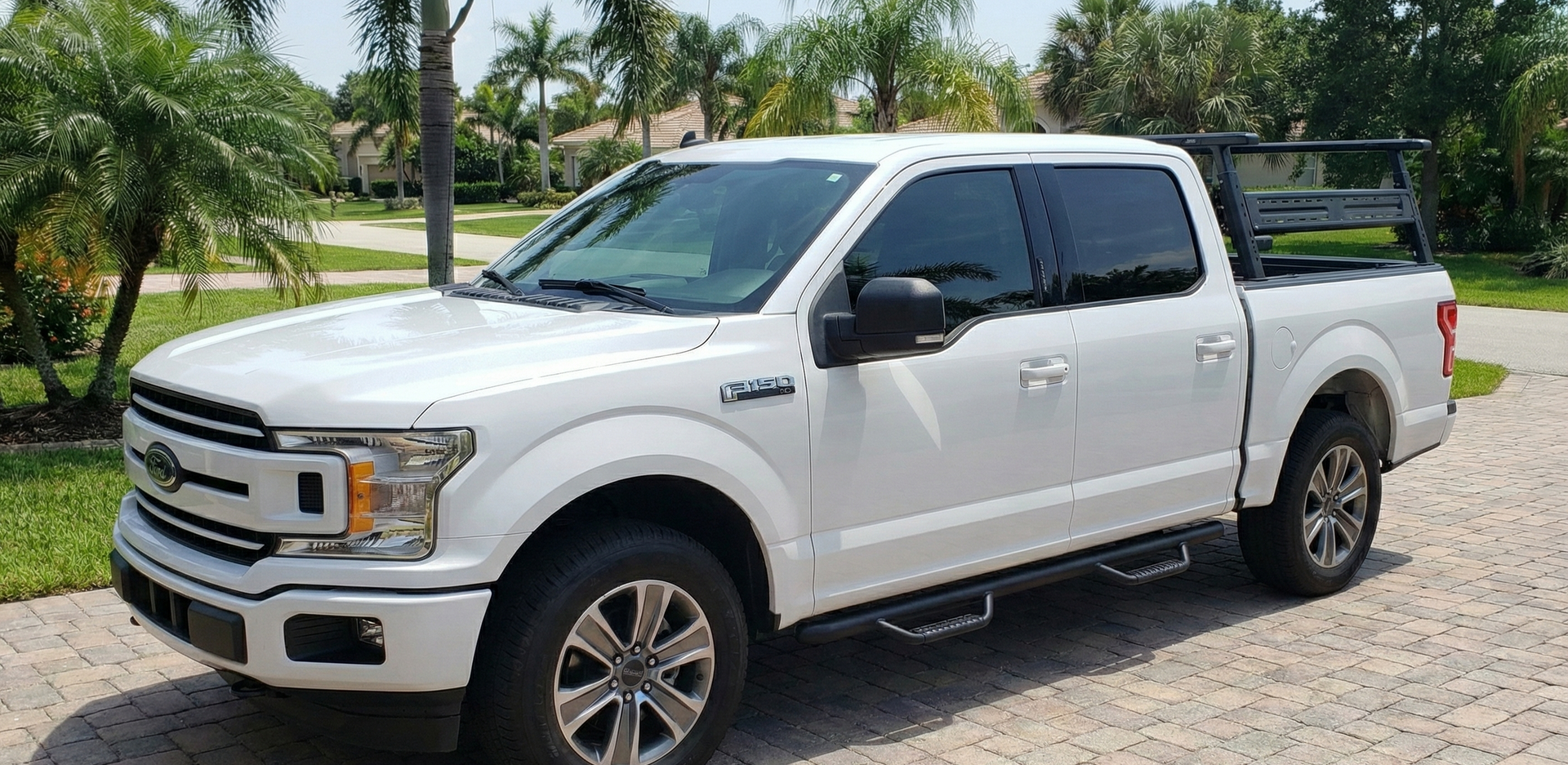Semi-truck driving on a wet road in the rain. Headlights illuminated, dark and overcast sky.