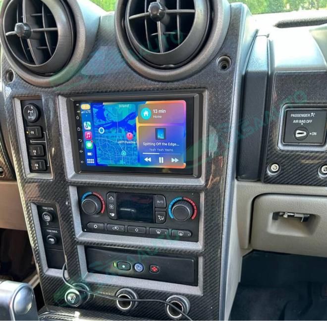 Interior view of a car dashboard, displaying a touchscreen infotainment system and air vents. Gray and black.