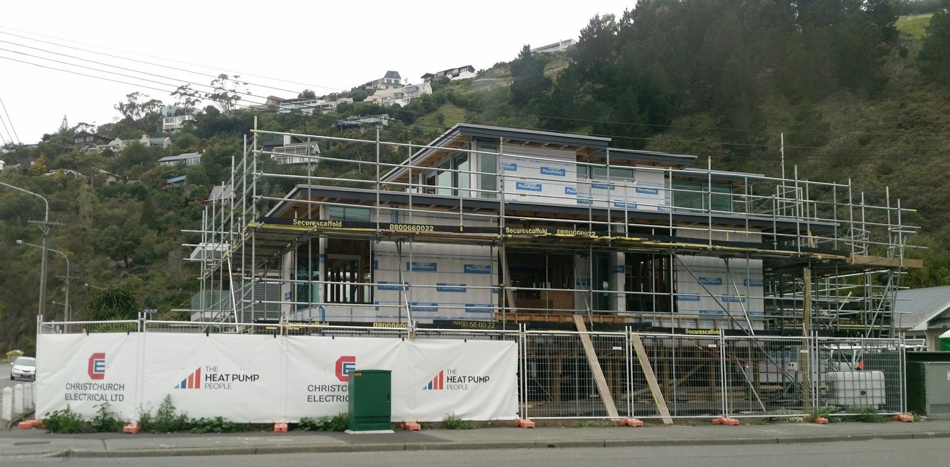 Building under construction, fence signage Christchurch Electrical, The Heat Pump People