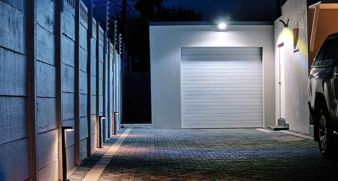 Security lighting above garage door and along pathway illuminating entrance