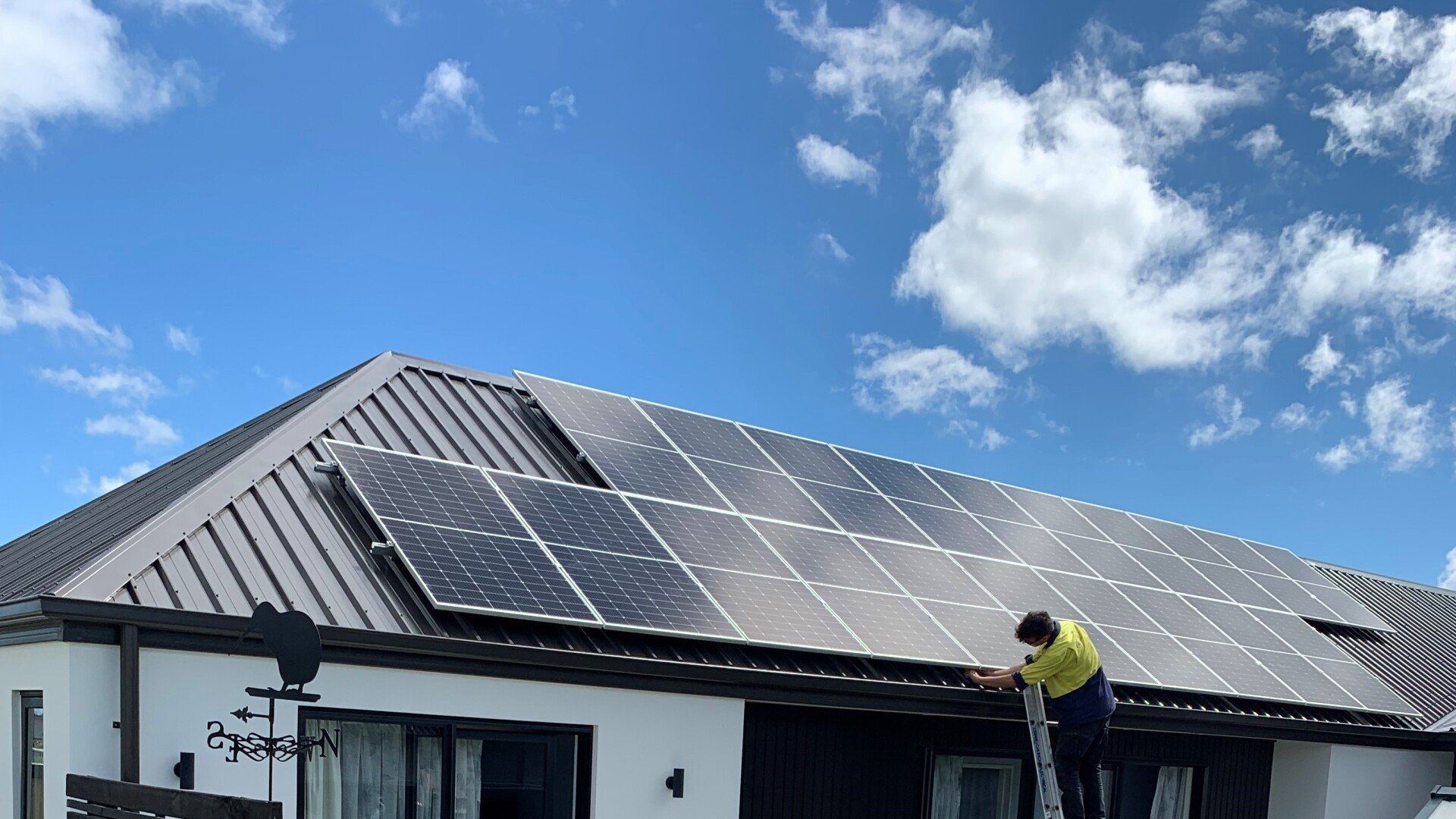 technician installing residential solar panels on roof