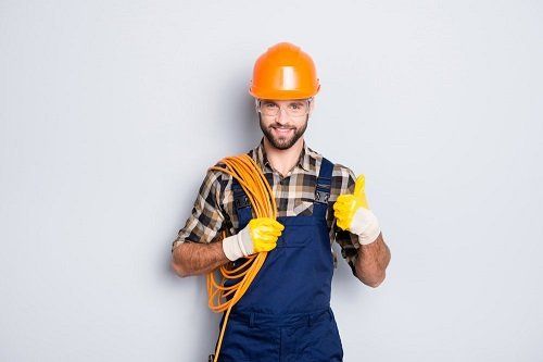 A smiling electrician holding a wire