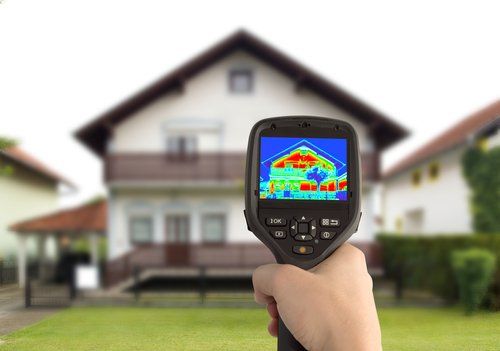 Thermal imaging tool held up in front of a house