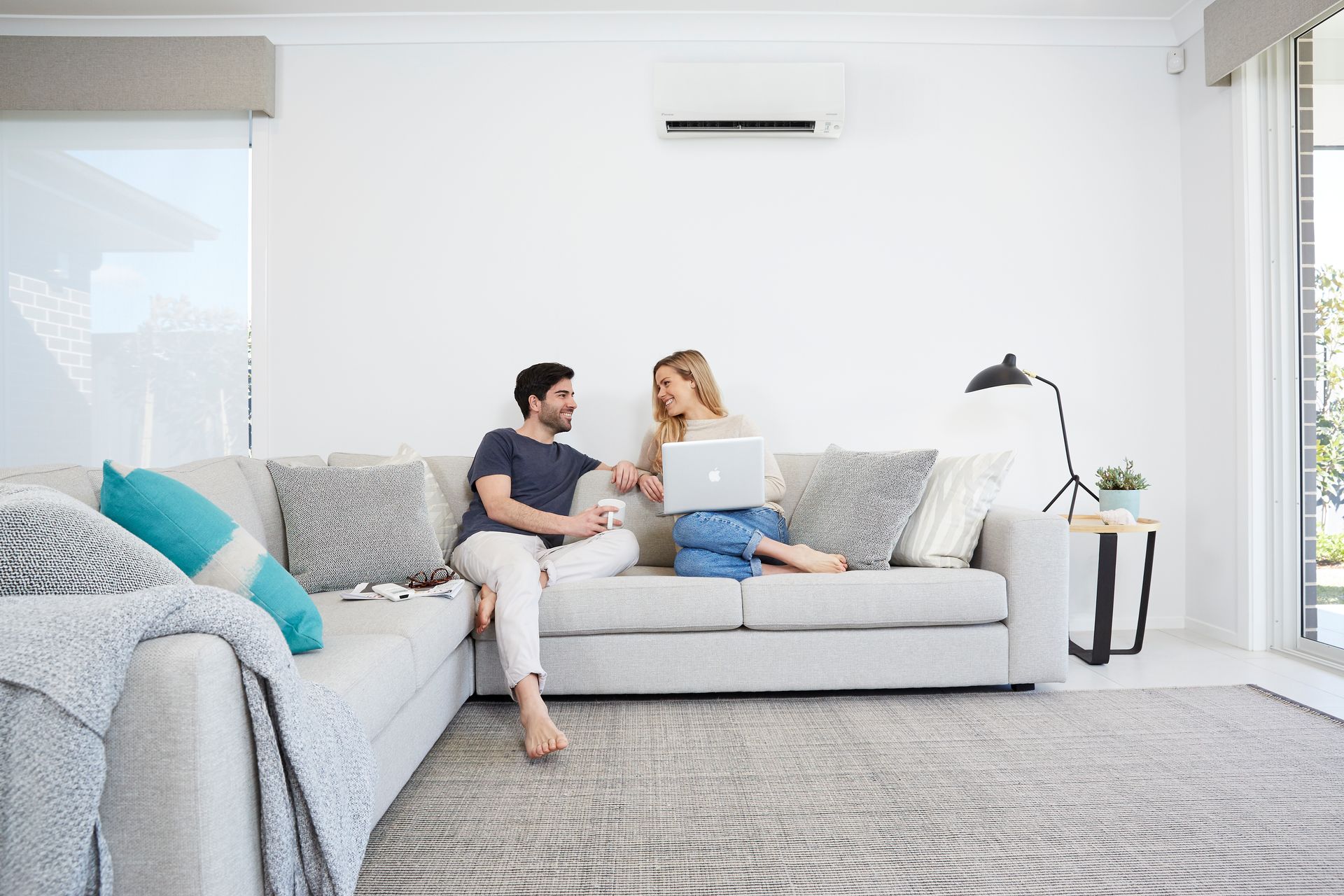 Couple on sofa with heat pump on wall