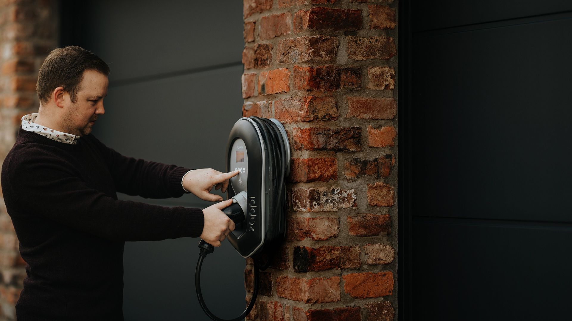 Person pressing control panel of Zappi EV Charger