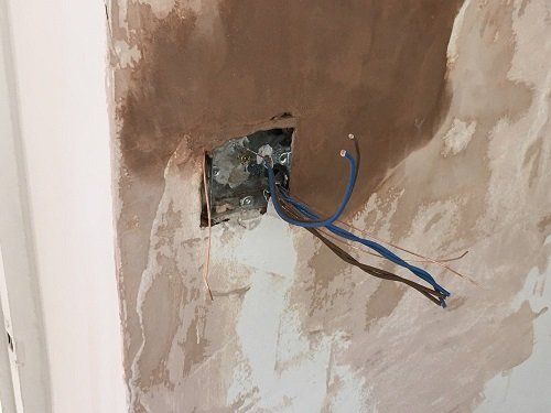 Electrical wires exposed through the wall
