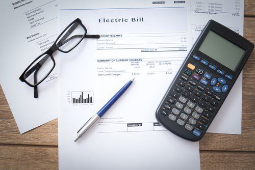 Electricity bill on table with calculator
