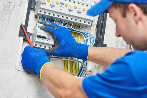 A professional electrician upgrading a switchboard