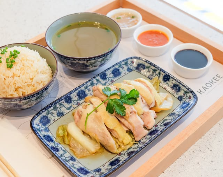 Plate of grilled chicken skewers with dipping sauce and colorful garnishes
