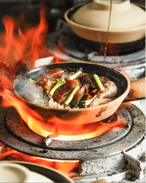 Flaming hot pot dish with seafood and vegetables being cooked tableside