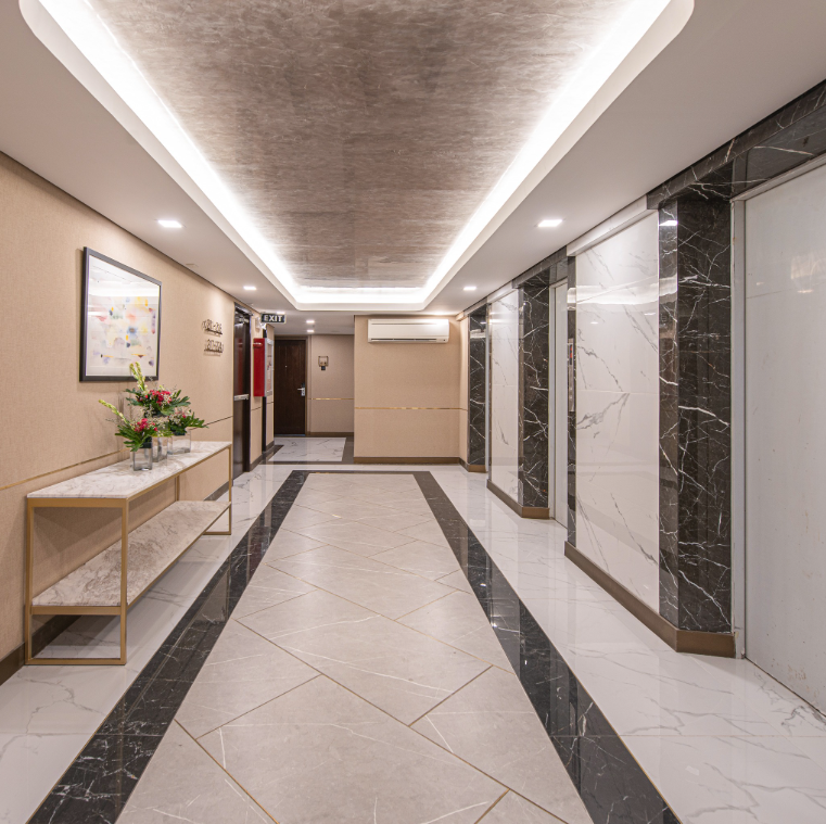 Elegant hotel corridor with patterned carpet and sophisticated wall lighting