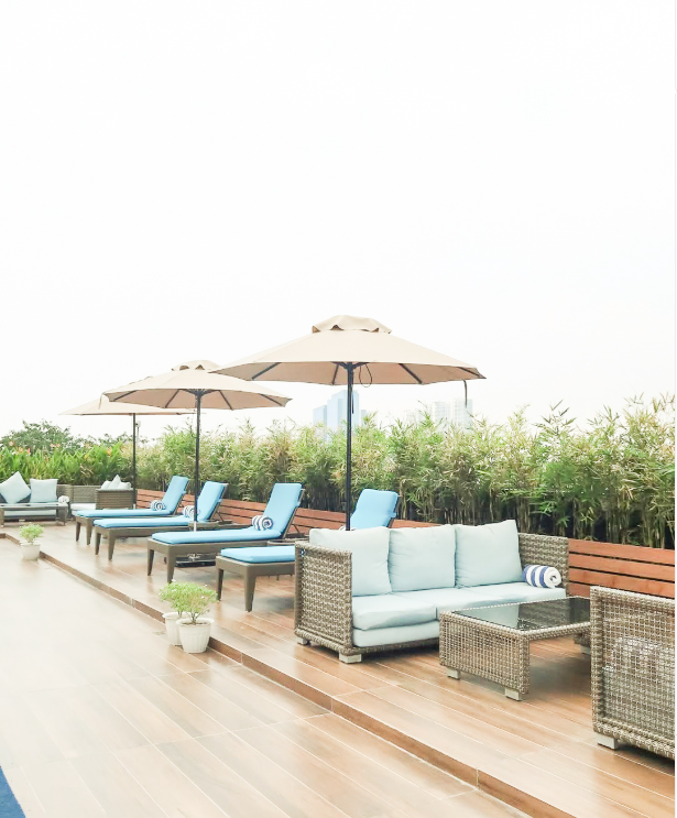 Outdoor pool area with lounge chairs and umbrellas for relaxation