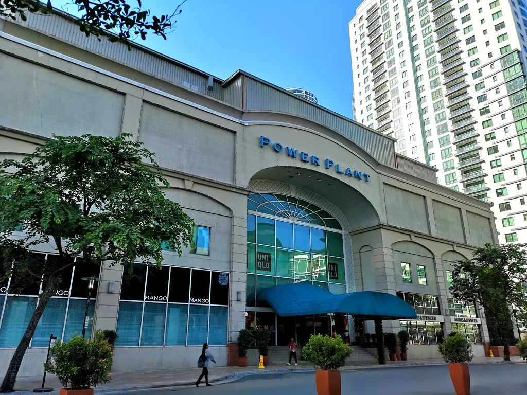 Power Plant Mall entrance with large sign, blue awning, and tall building in the background.