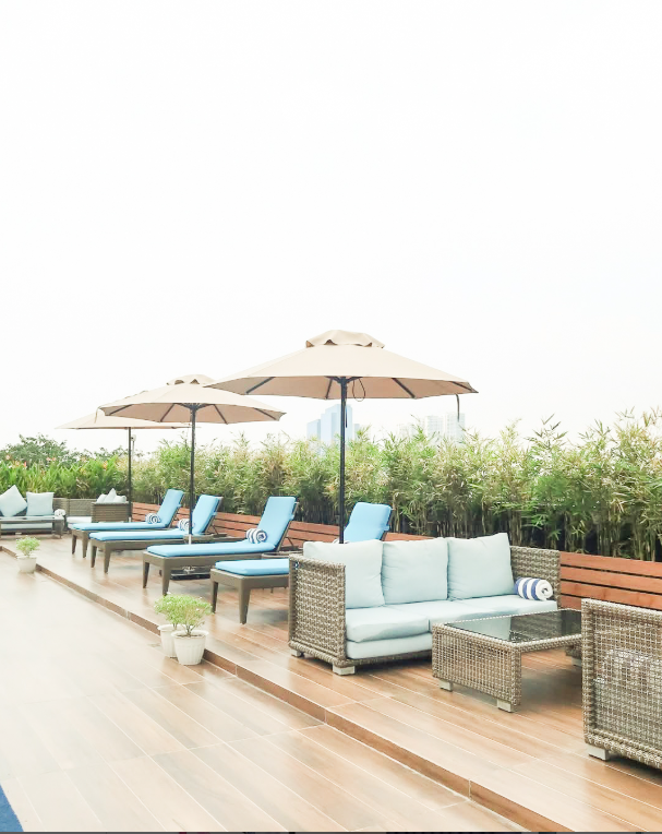 Poolside lounge area with sun beds and seating at a luxury resort in Makati