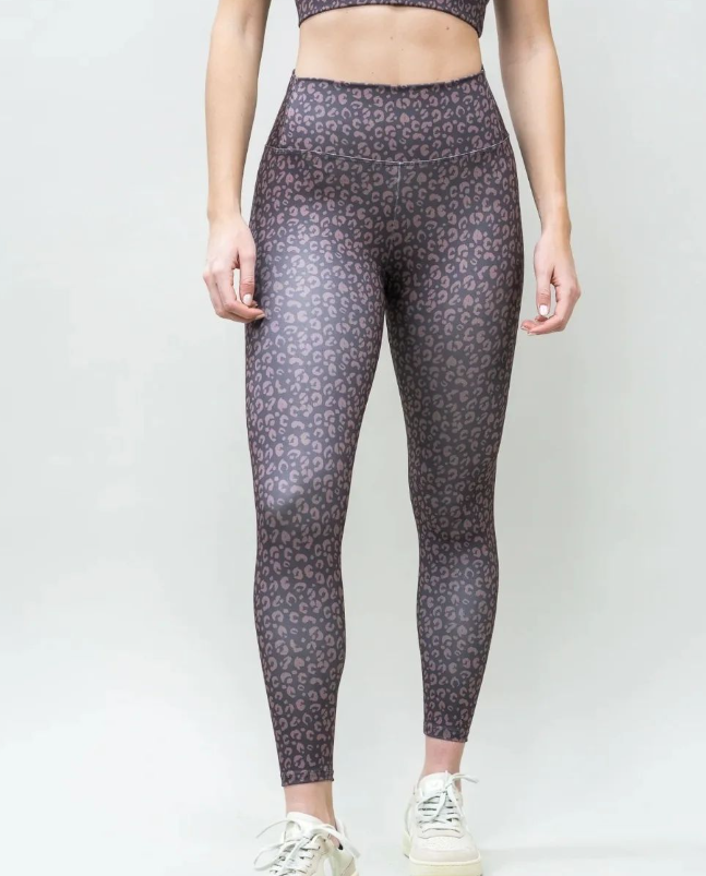 Una mujer que lleva un top corto y leggings con estampado de leopardo.