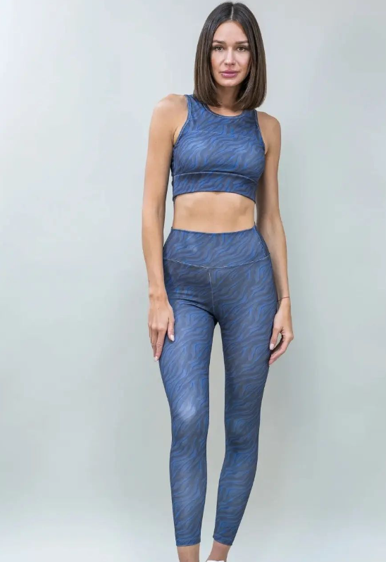 Una mujer lleva un top azul y leggings azules.