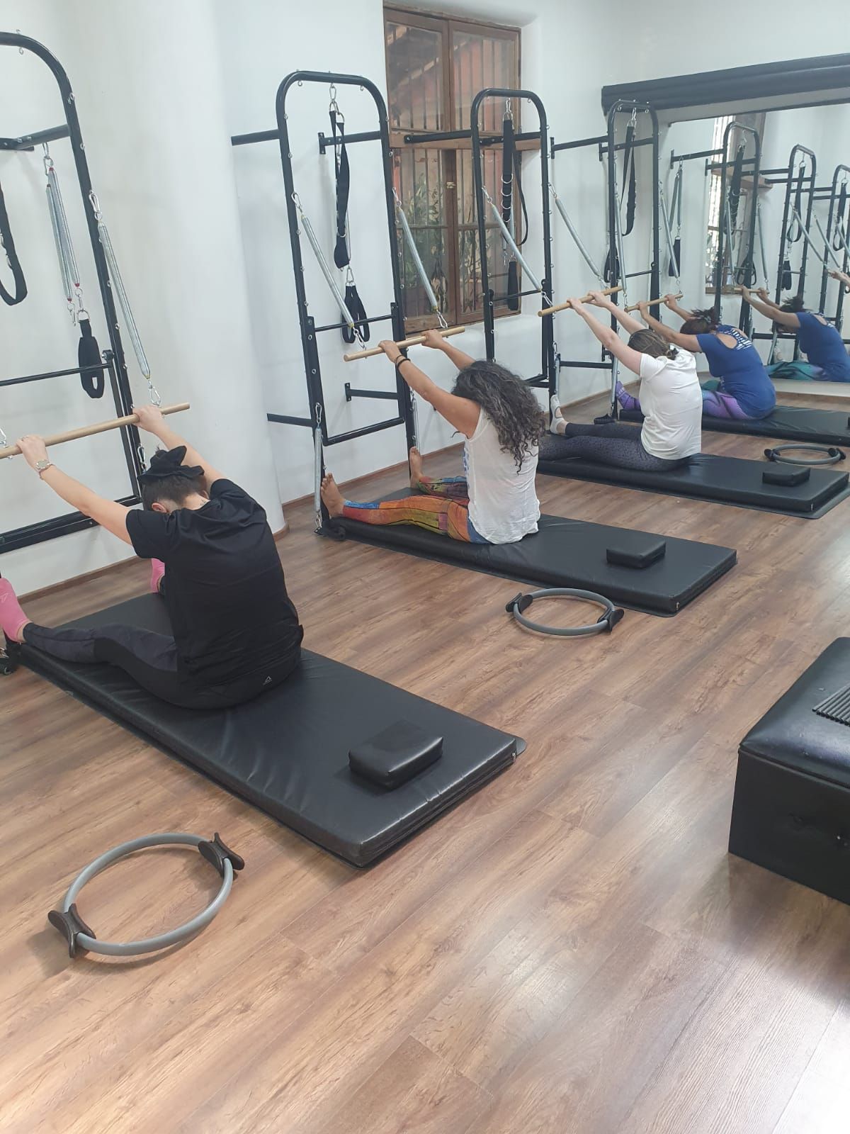 Un grupo de personas está haciendo pilates en un gimnasio.