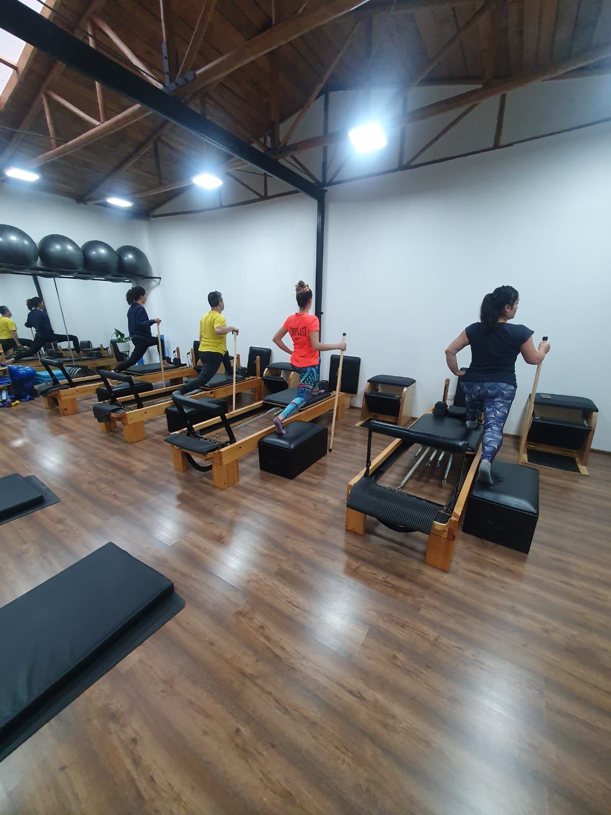 Un grupo de personas está haciendo pilates en un gimnasio.