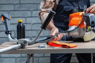 A chainsaw chain sharpening tool with a chain in place, red and silver.
