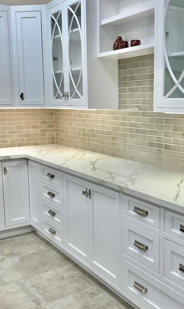 Kitchen with tiled backsplash, quartz countertops and custom cabinets