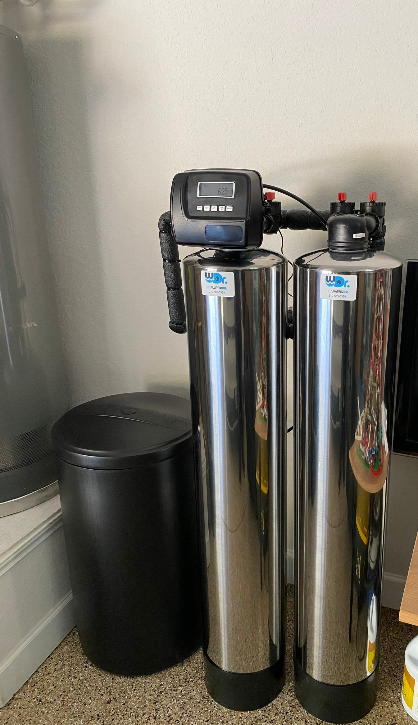 Water softener system with black and silver tanks, electronic control panel.