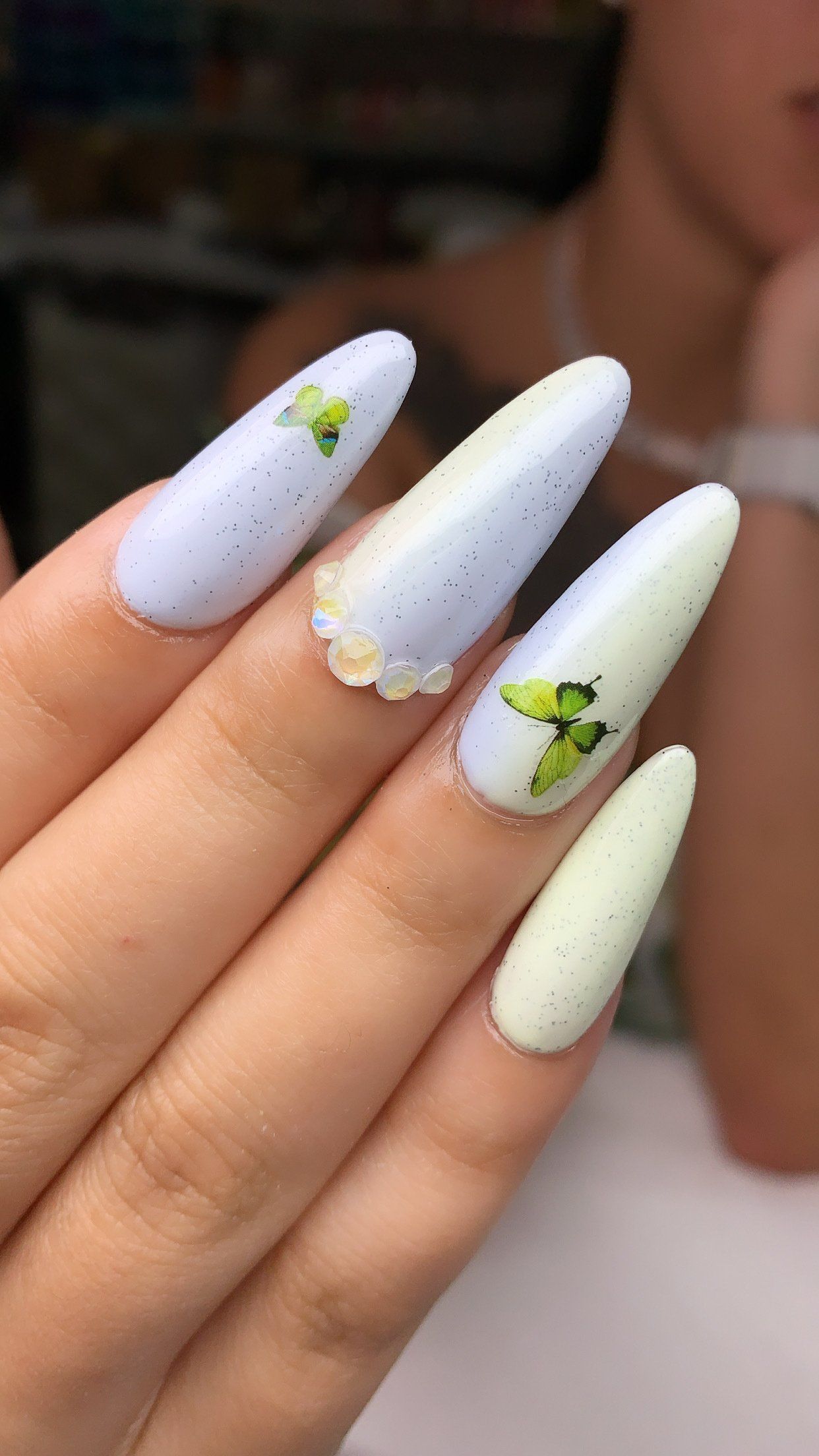 A close up of a person 's nails with a butterfly on them.
