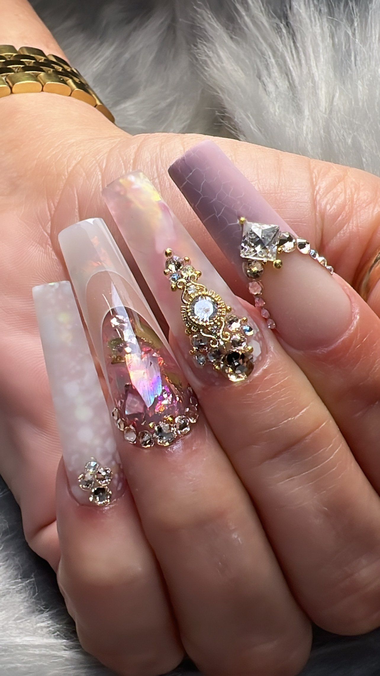 A close up of a woman 's hand with long nails and rhinestones.