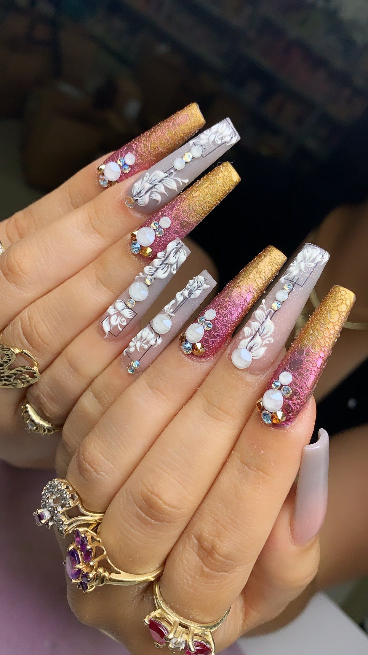A close up of a woman 's nails with rings on her fingers.