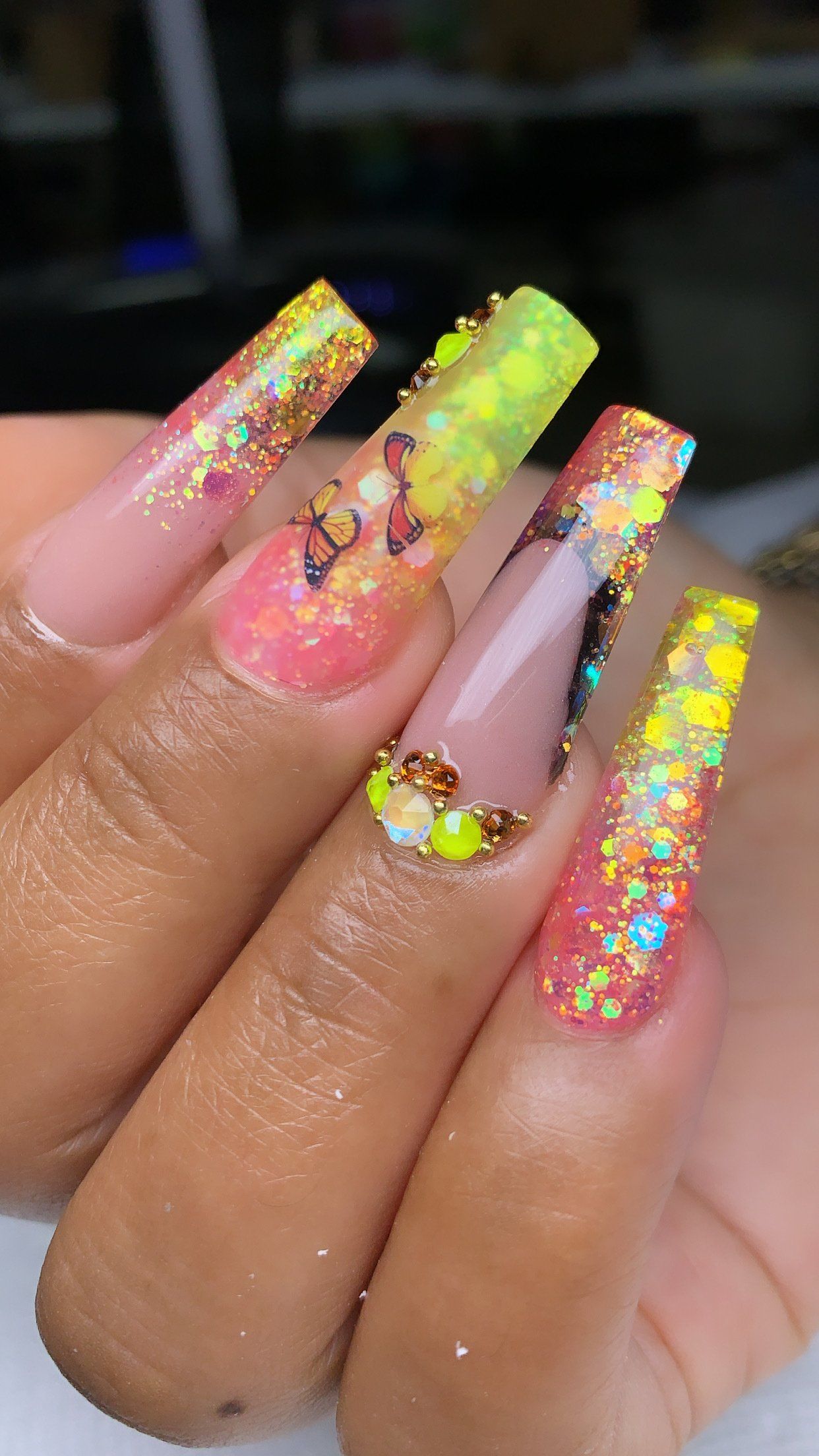 A close up of a person 's nails with glitter and rhinestones.