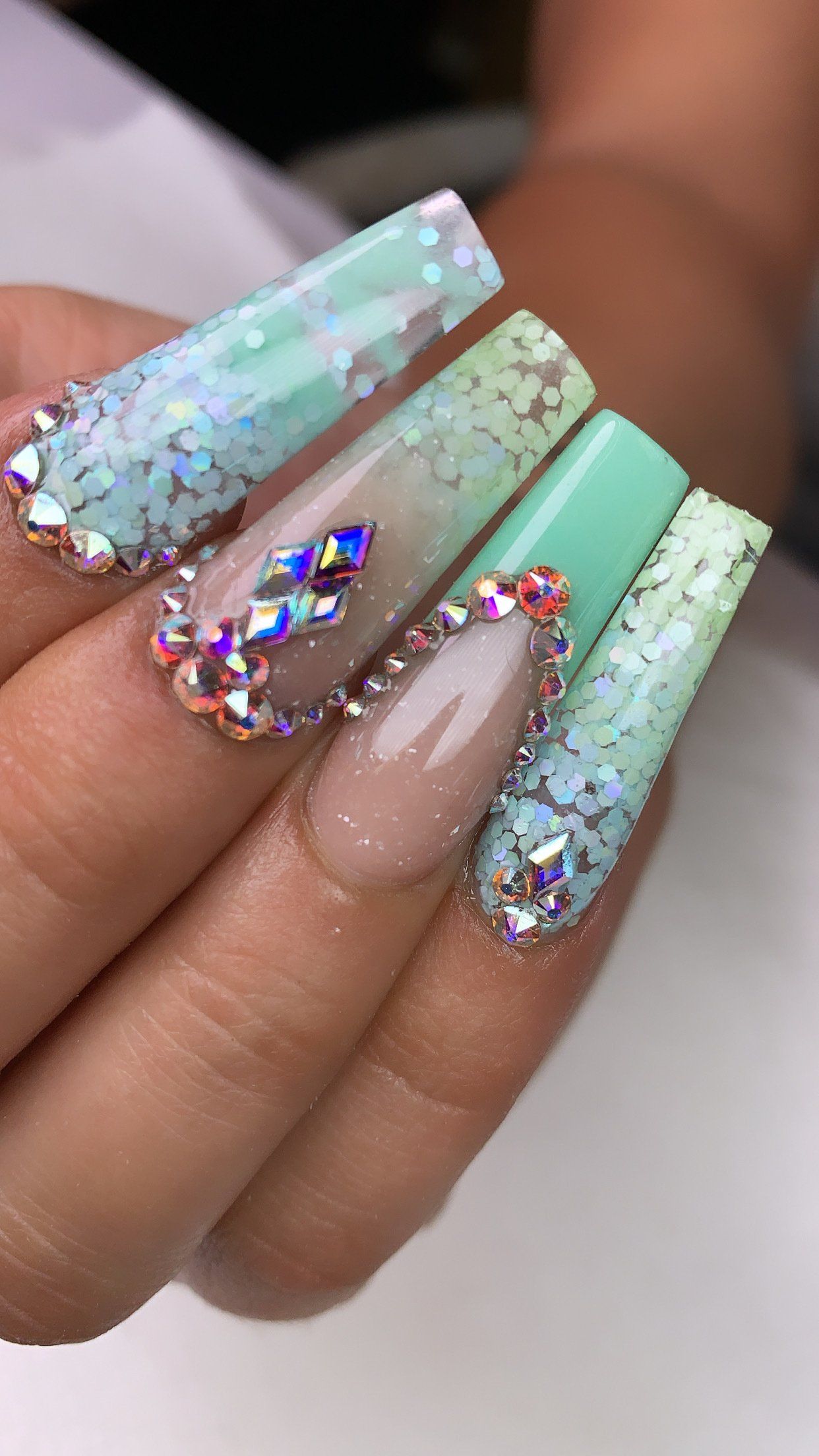 A close up of a person 's nails with rhinestones on them.