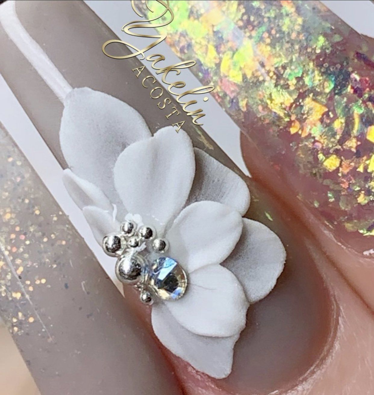 A close up of a nail with a flower on it