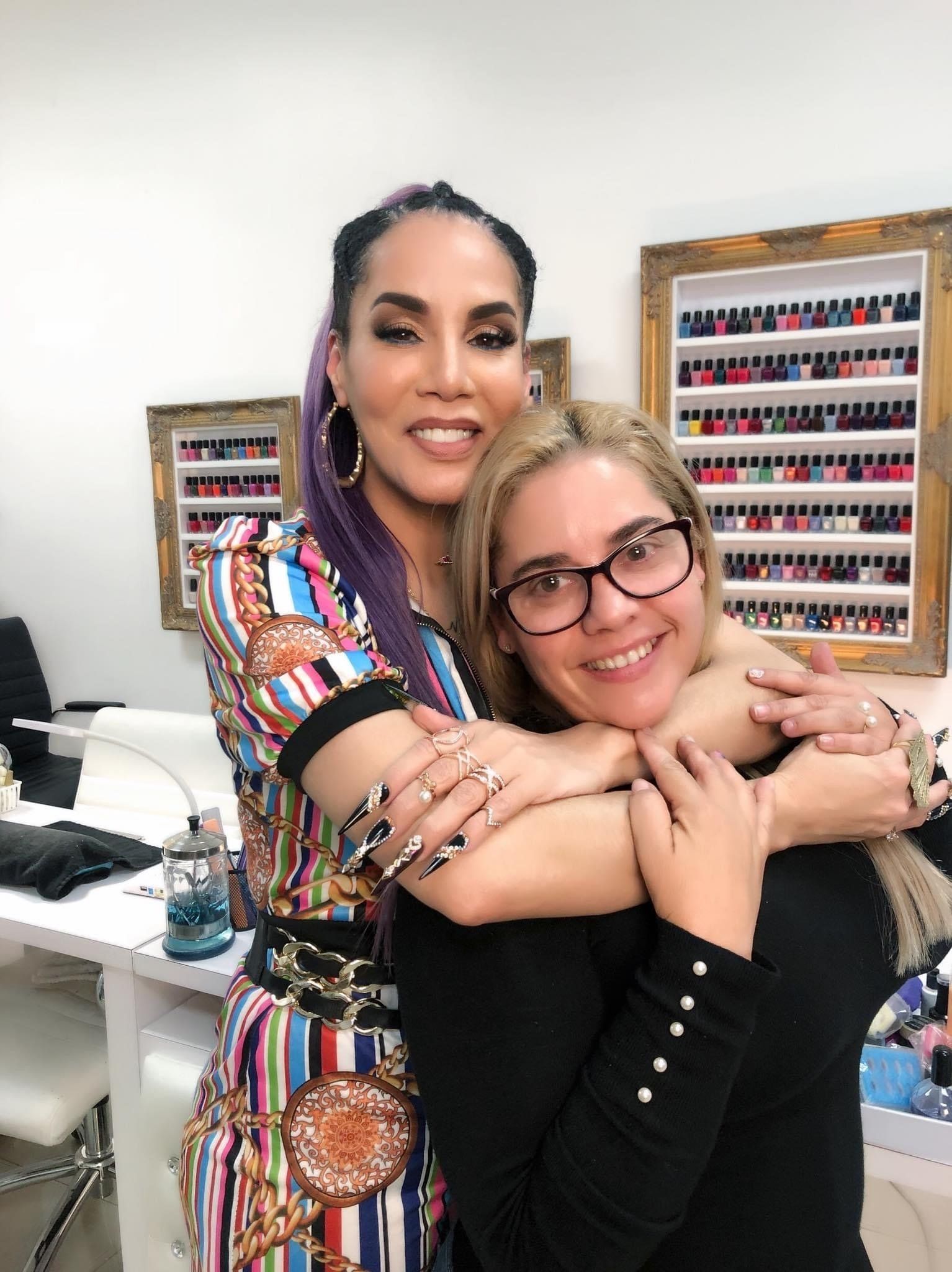 Two women are hugging each other in a salon.