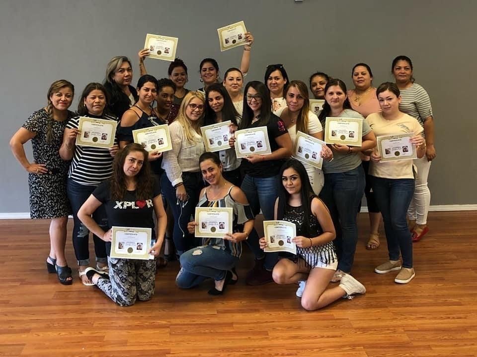 A group of women are posing for a picture while holding certificates.