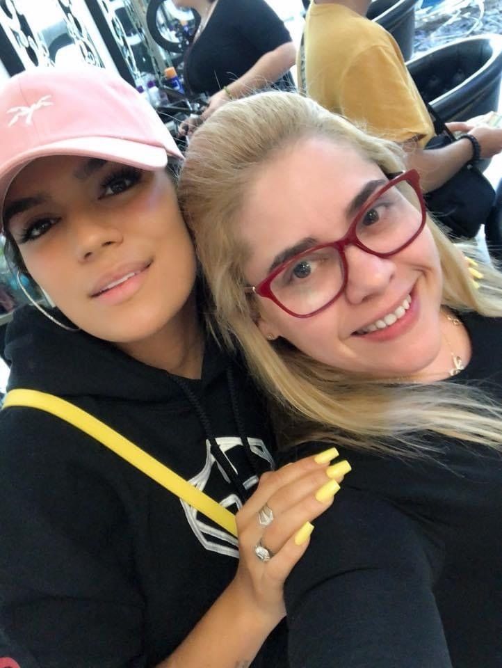 Two women are posing for a picture and one is wearing glasses