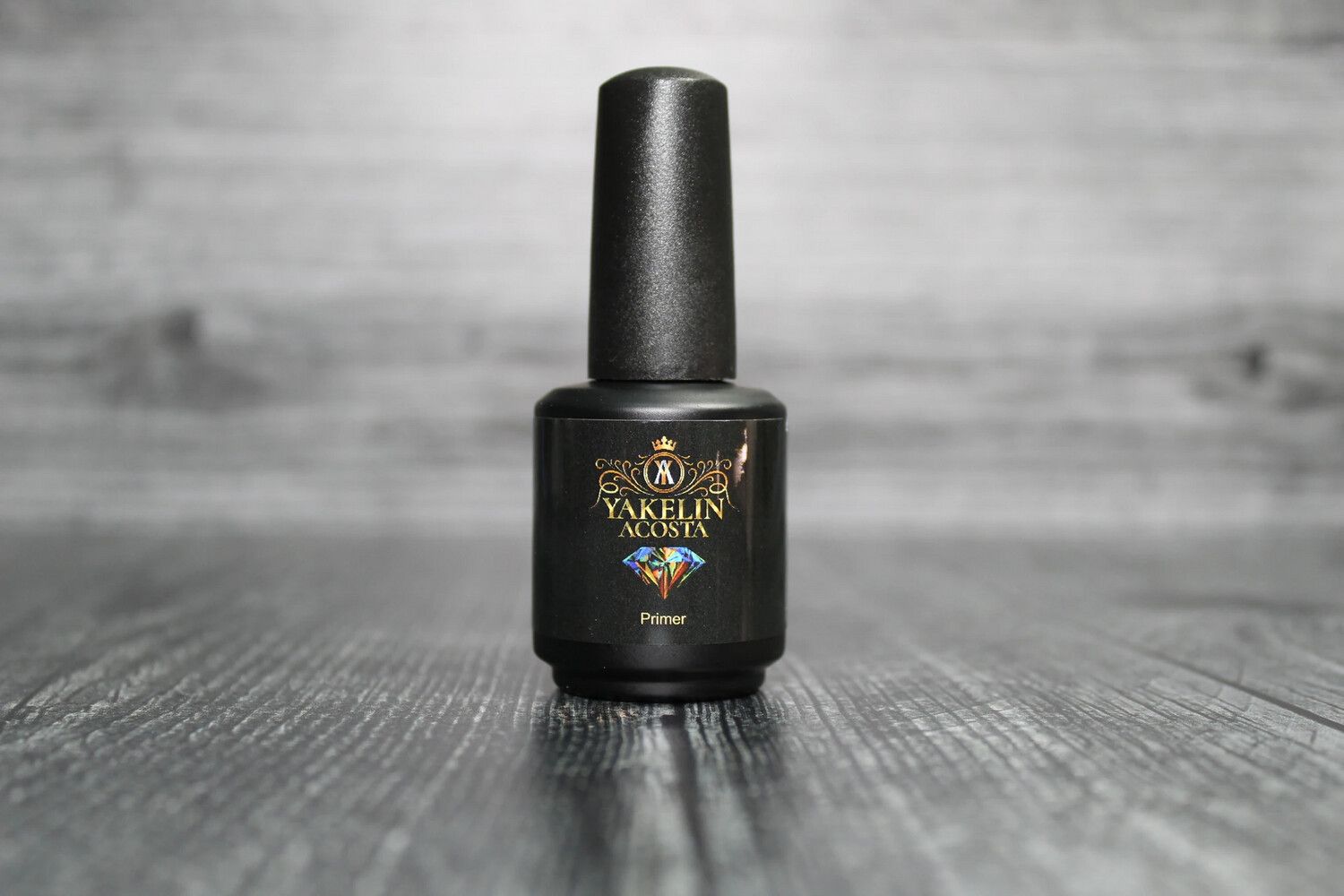 A bottle of nail polish is sitting on a wooden table.