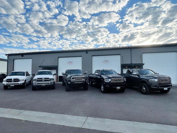 A row of trucks are parked in front of a building.