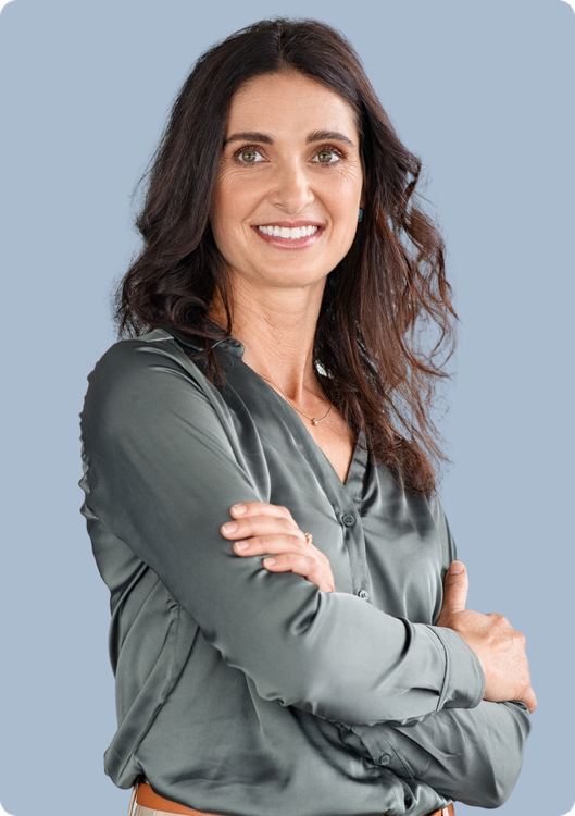 Woman with dark hair, smiling, arms crossed. She wears a green silk shirt, in front of a blue background.