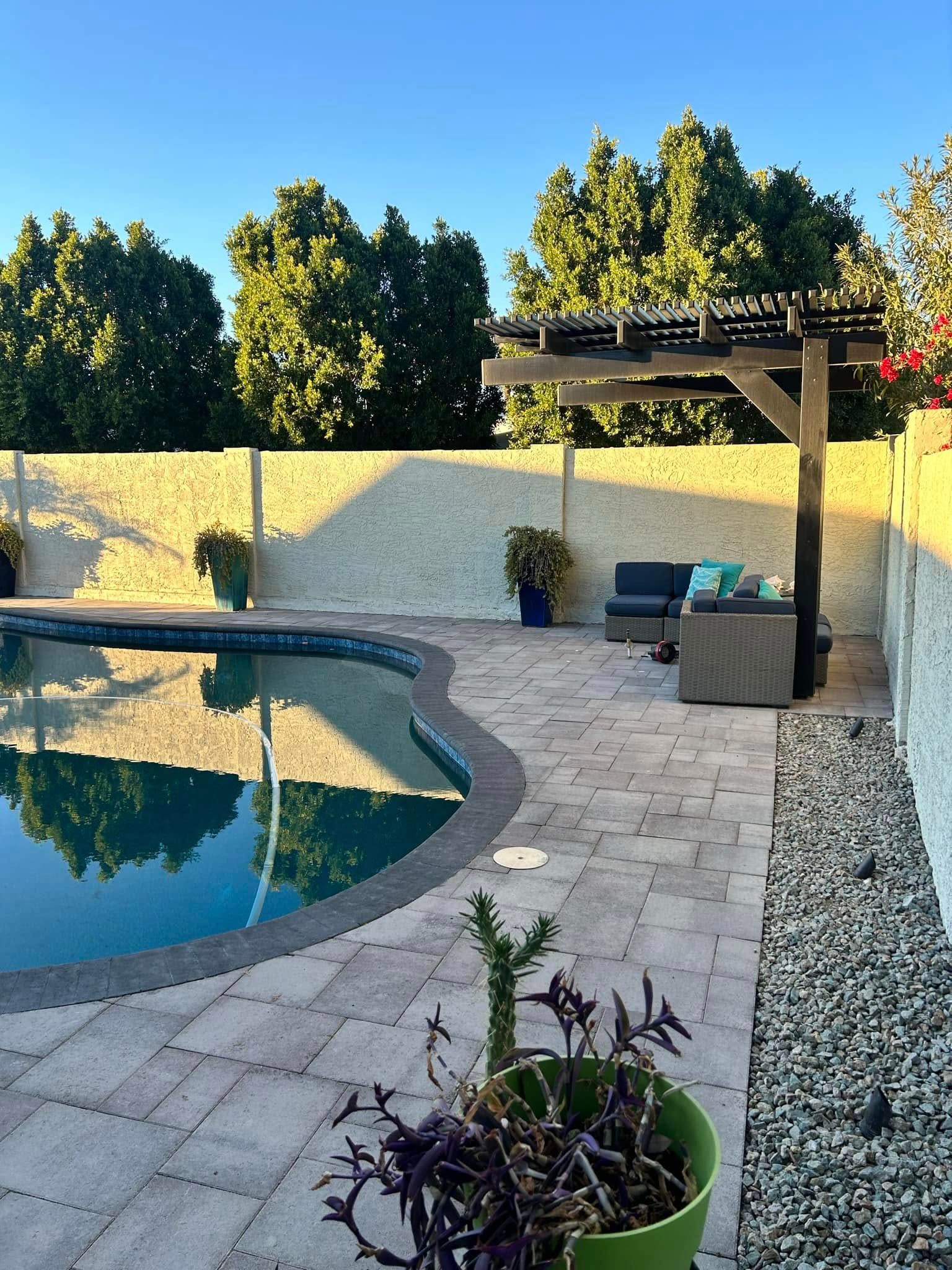 A patio with a swimming pool and a pergola