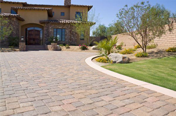 A large house with a brick driveway leading to it.
