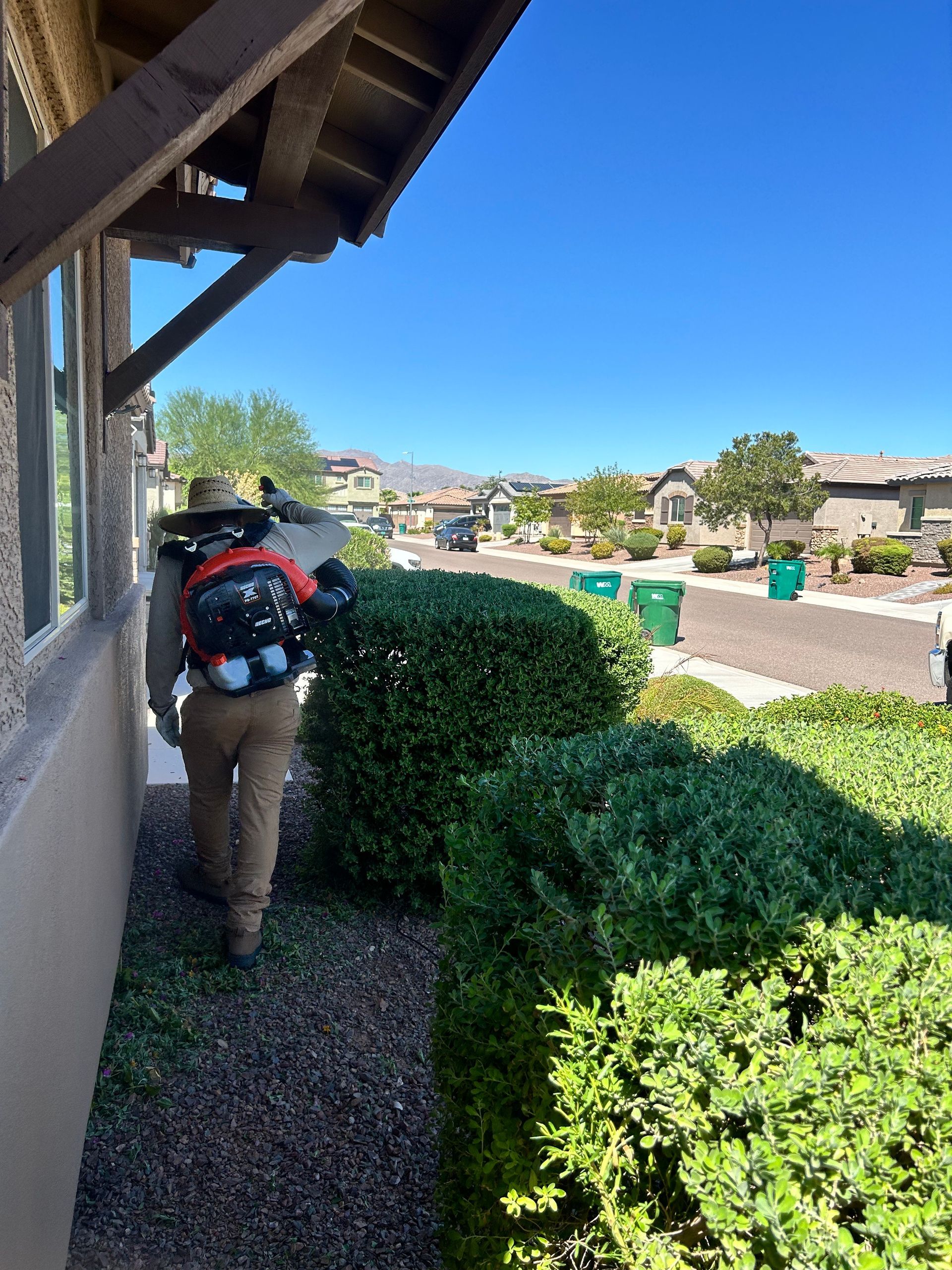 A man is walking down a sidewalk next to a building.