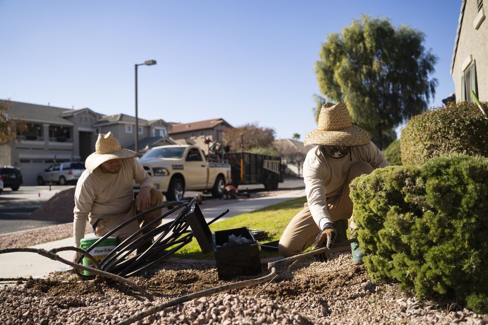 Two men are working in a garden in front of a house.