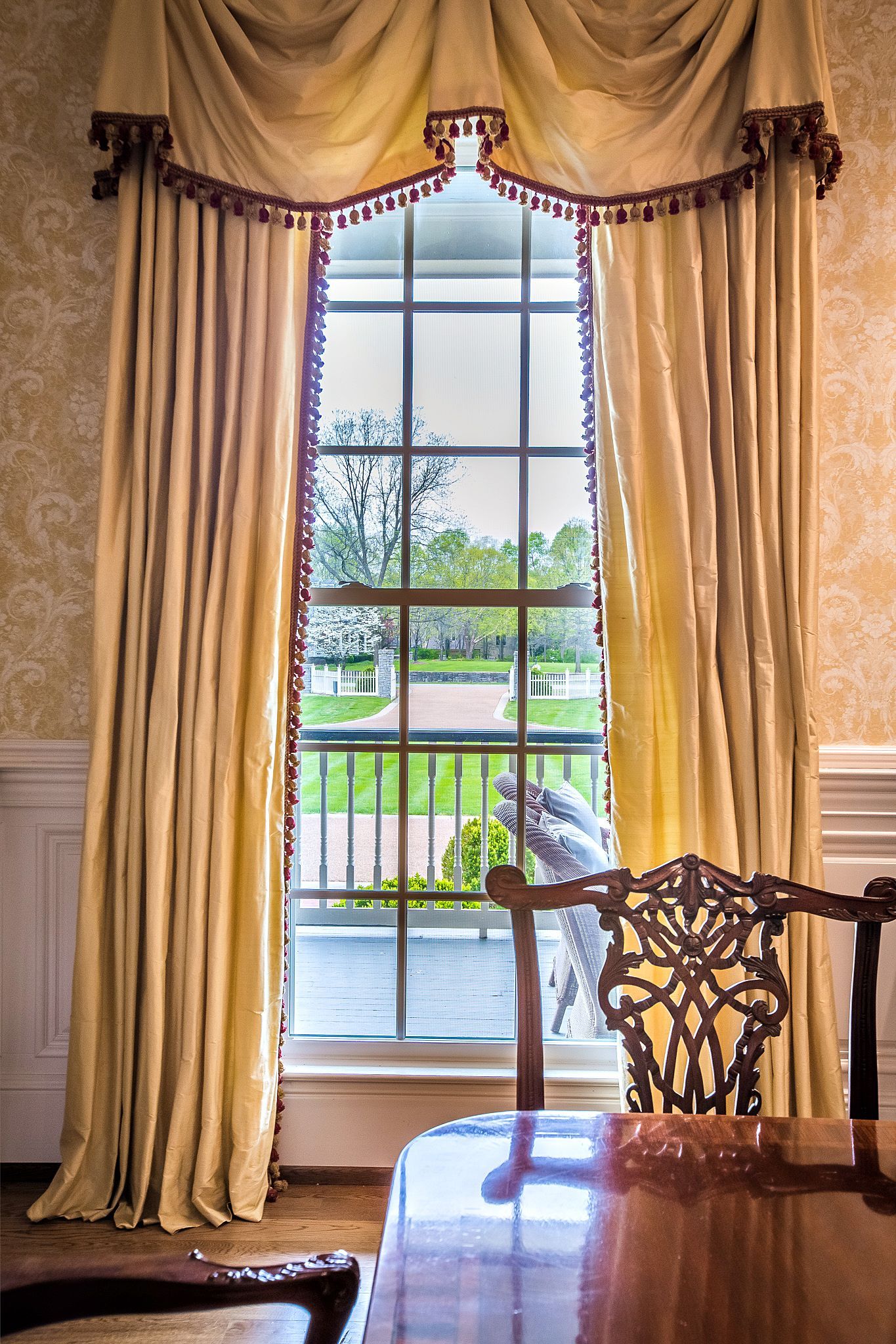 A dining room with a table and chairs and a large window.