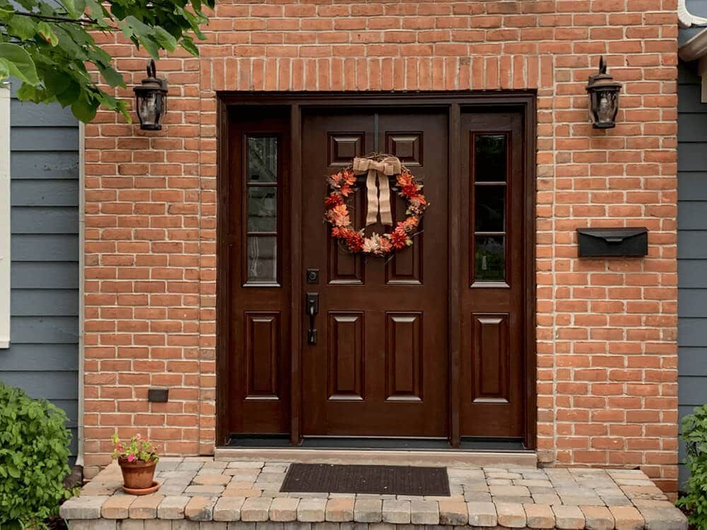 The front door of a brick house with a wreath on it