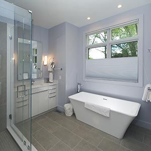 A bathroom with a tub , sink , mirror and shower.