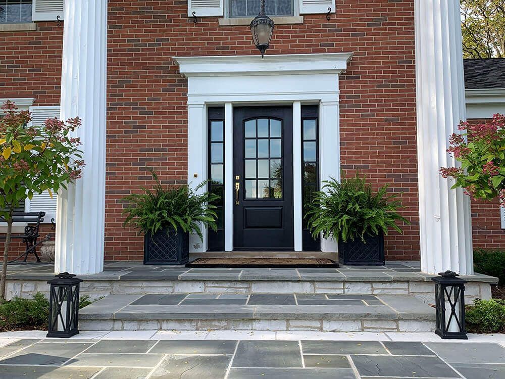 The front door of a brick house with a black door