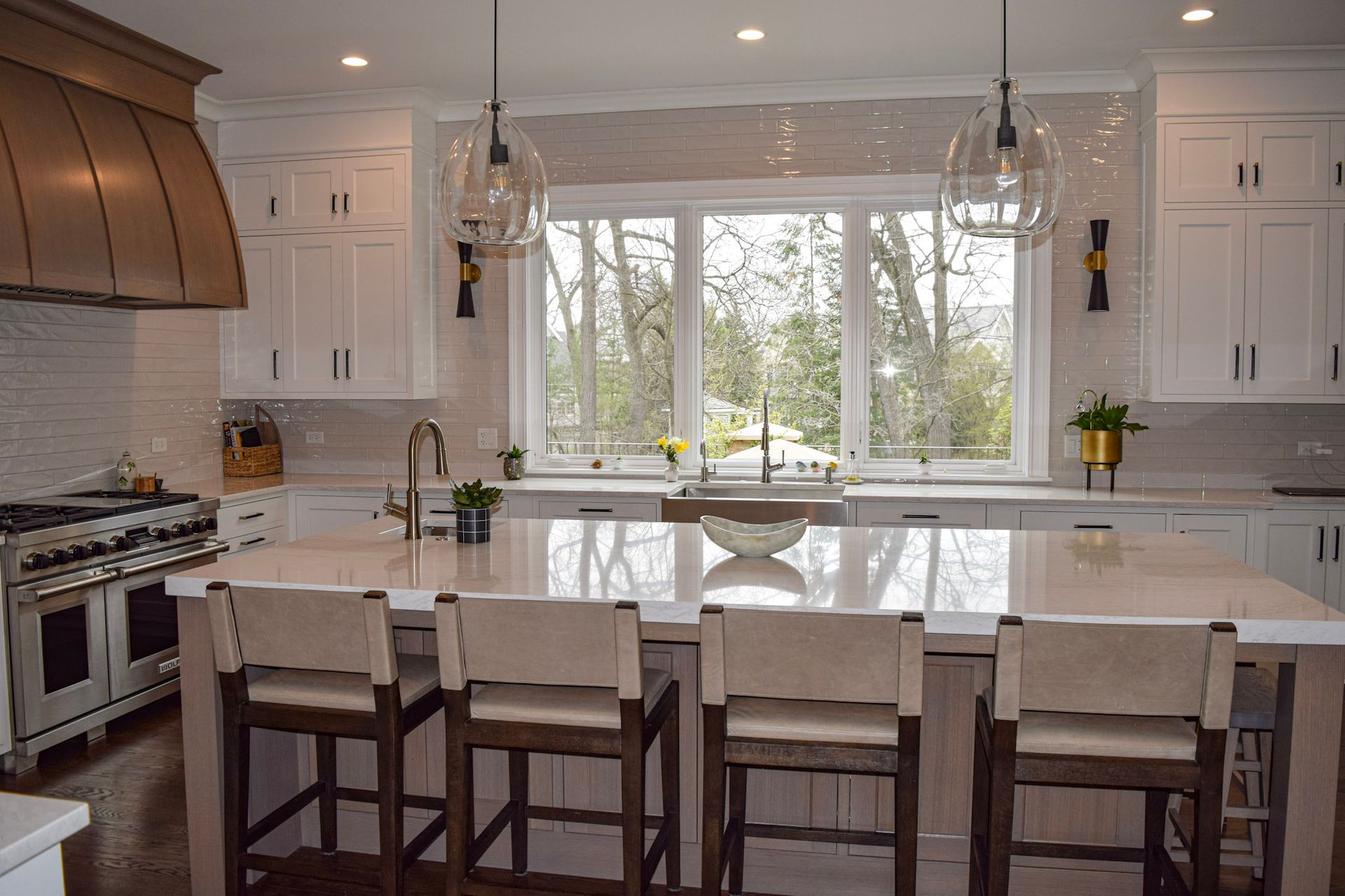 Modern kitchen with white cabinets, stainless steel appliances, and a large island with bar seating.