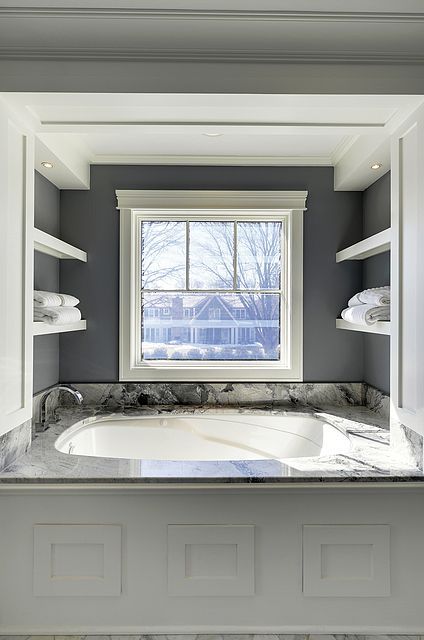 A bathroom with a bathtub and a window.