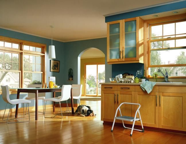 A kitchen with a table and chairs and a dog laying on the floor