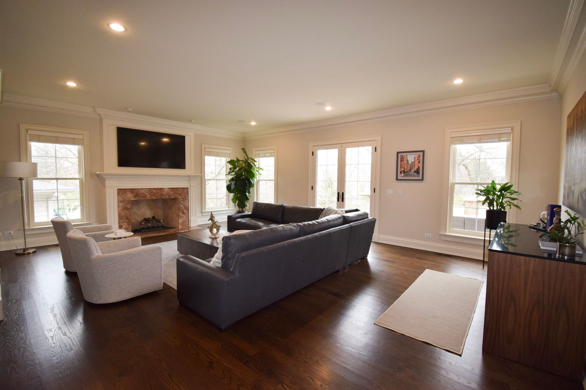 Spacious living room with dark wood floor, fireplace, and a gray sectional sofa.