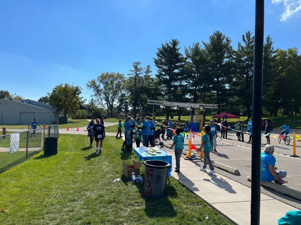 A group of people are standing around a table in a park.